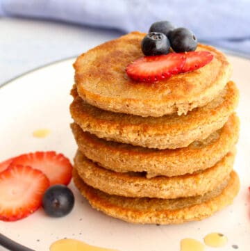 a staple of oat flour panckaes with blueberries and strawberries on top