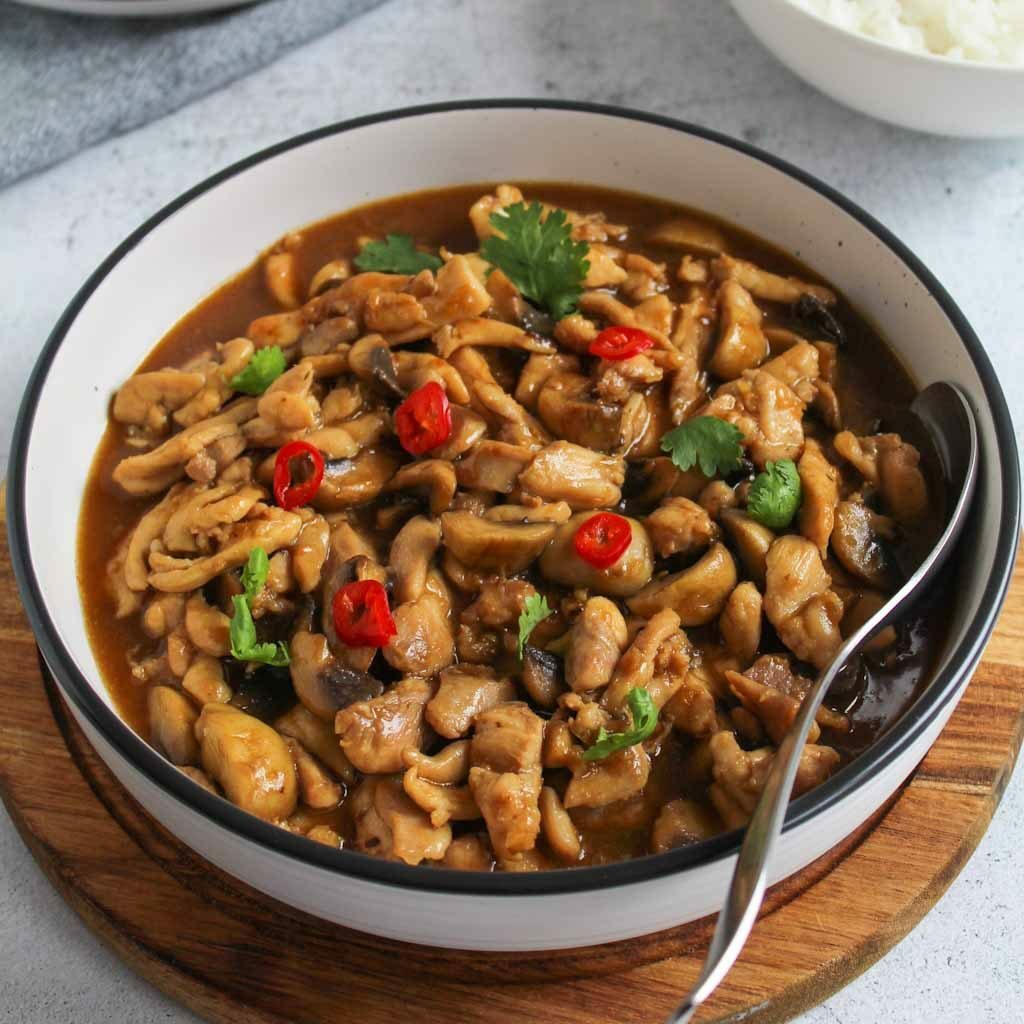 lemon chicken with mushrooms in a bowl with chilly and coriander