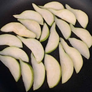 pear slices for arugula salad in a frying pan