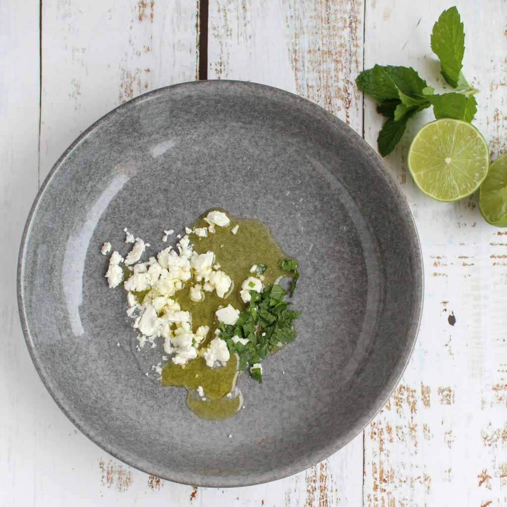 feta, olive oil and mint leaves in a grey plate