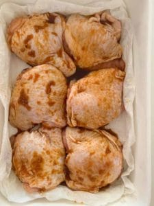 six chicken thighs in a marinade
