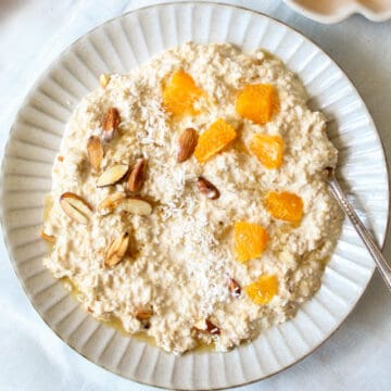 creamy overnight oats in a bowl with oranges and nuts