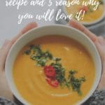 two hands holding a bowl with carrot soup