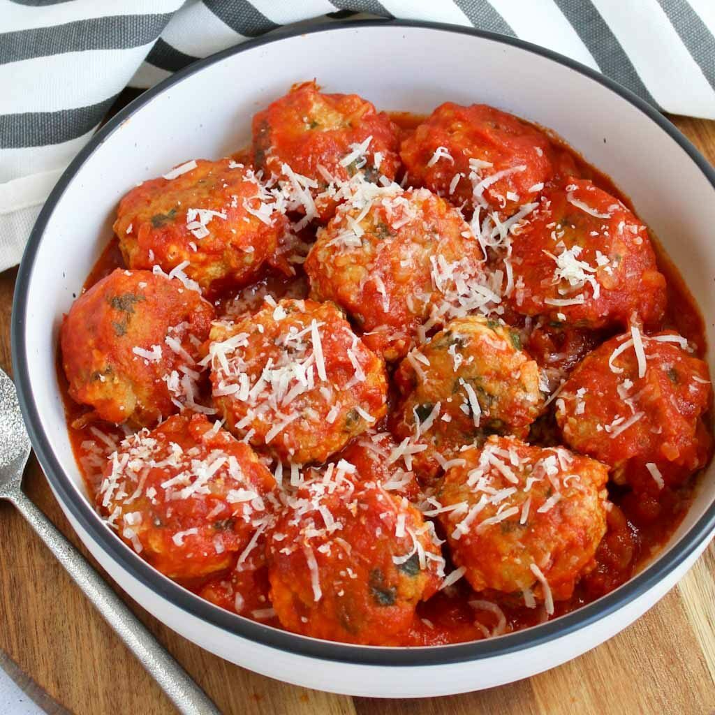 chicen meatballs in tomato sauce with parmesan on top