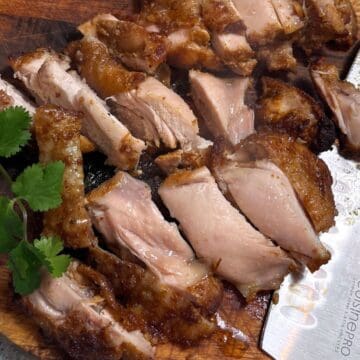 Juicy sliced chicken shawarma with charred edges on a wooden board, ready to serve in wraps, rice bowls or salads.