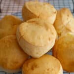 Brazilian cheese rolls on a cooling rack.
