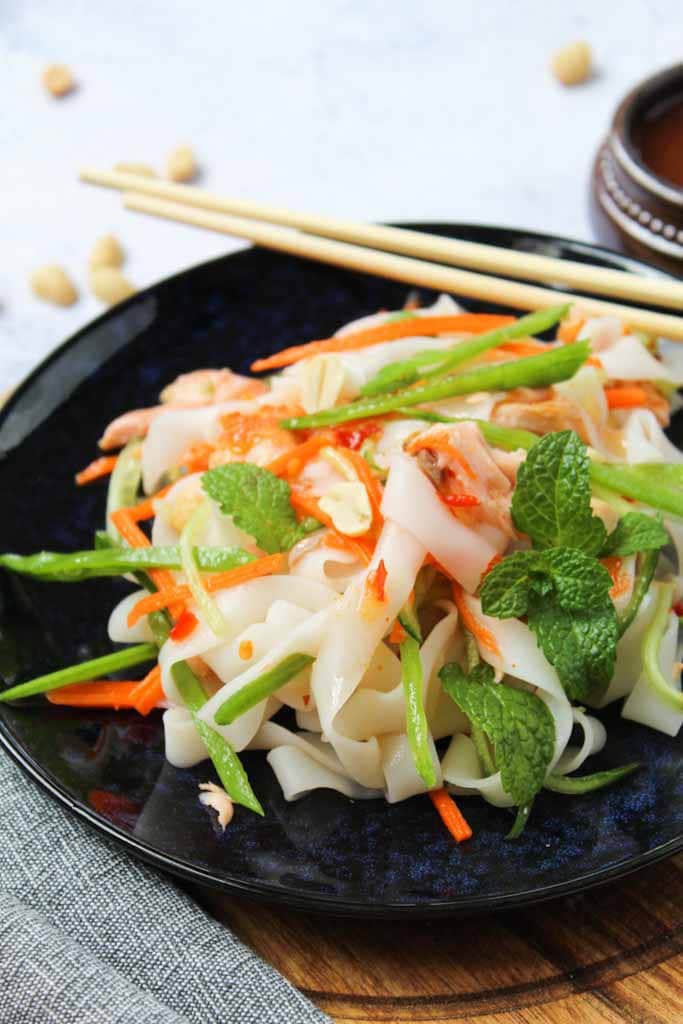 rice noodles with fresh carrots, cucmbers and mint on a blue plate
