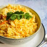 Rice with carrots in a grey bowl.
