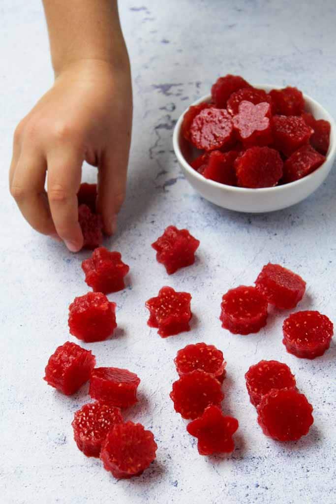 a child hand taking a raspberries jelly from the table