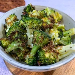 roasted broccoli florets in a white round bowl