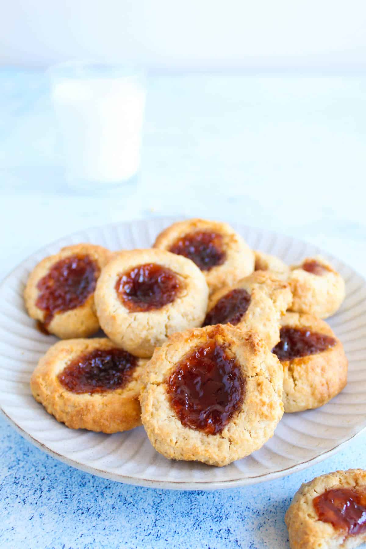 jam drop cookies on a plate served with glass of milk