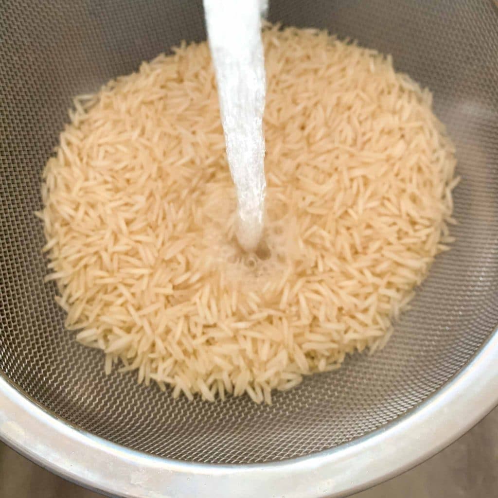 washing rice in a mesh colander 