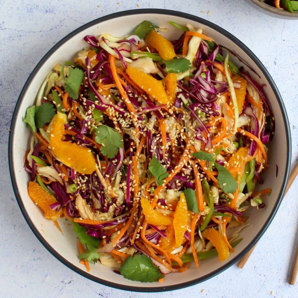 colorful Chinese chicken and orange salad on a white plate