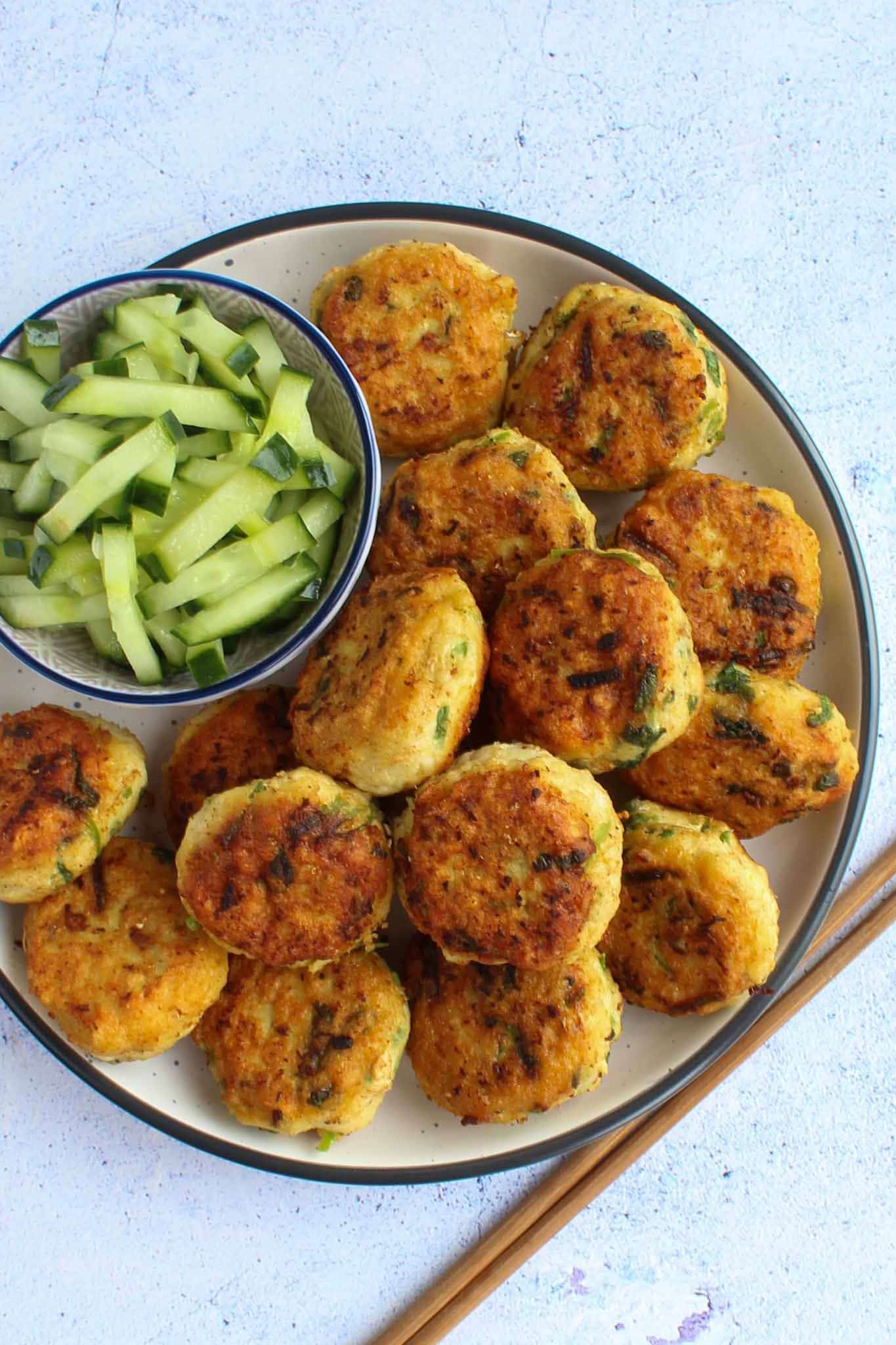 Thai fish cakes on a round plate with cucumber relish