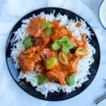 Butter chicken served over basmati rice with cherry tomatoes.
