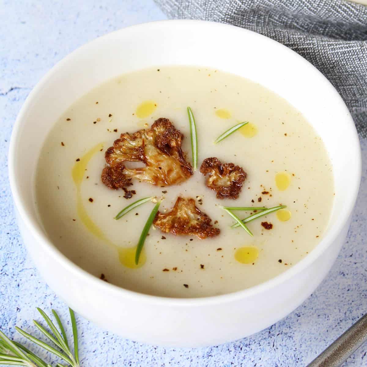 a bowl with creamy cauliflower soup and cauliflower chips