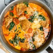 Creamy Tuscan Chicken thighs in a grey frying pan.