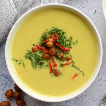 creamy cauliflower soup served with fresh cilantro and roasted chickpeas