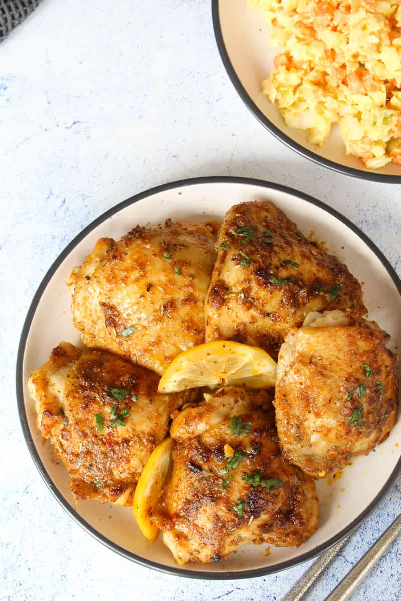 six tray baked chicken thighs on a plate