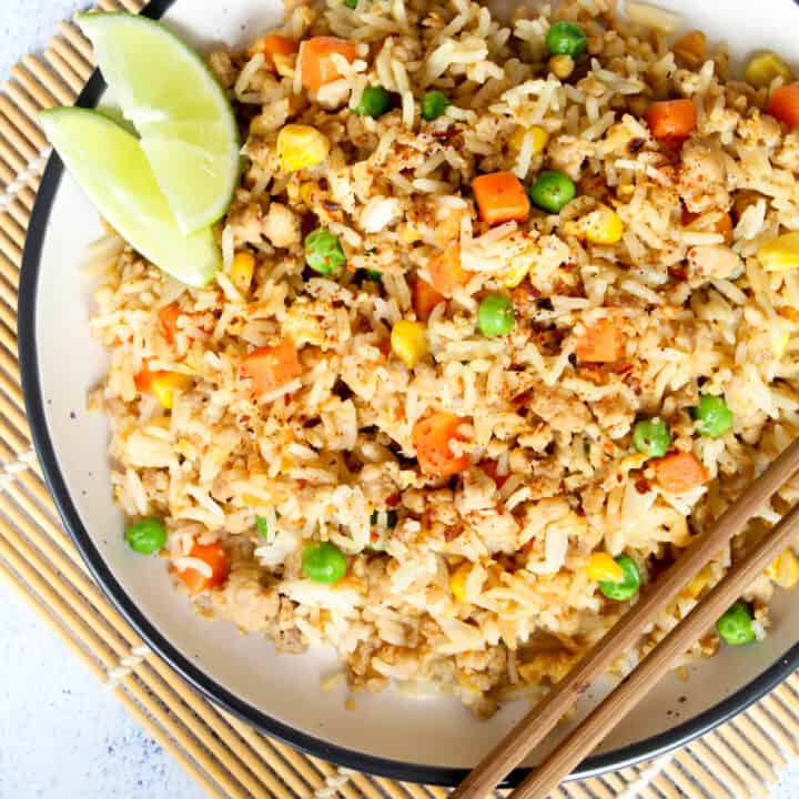 healthy fried rice on a plate with lime wedges