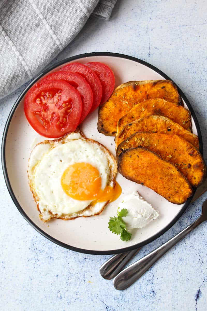 baked sweet potatoes with fried egg and tomato slices