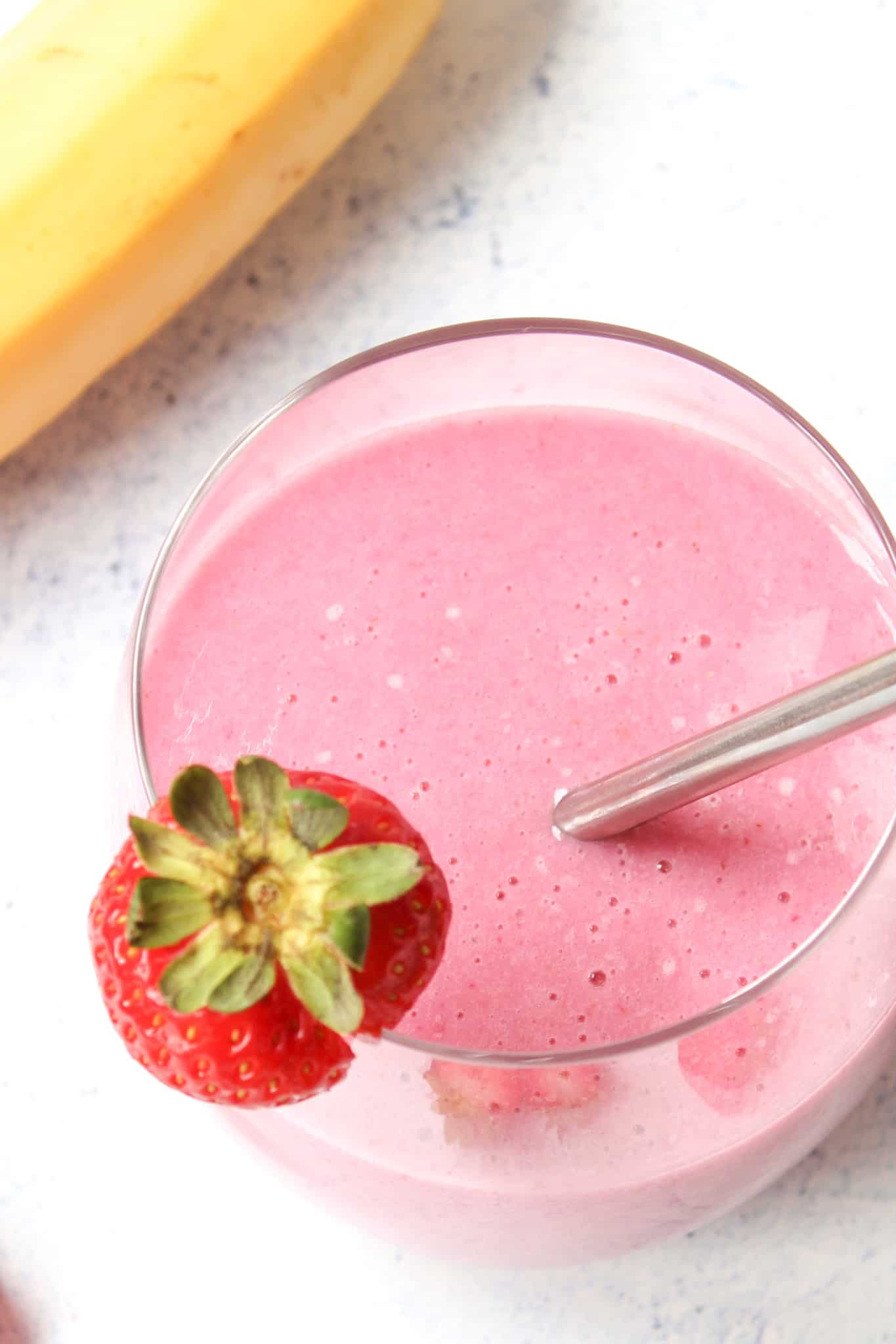 a glass with strawberry and banana smoothie