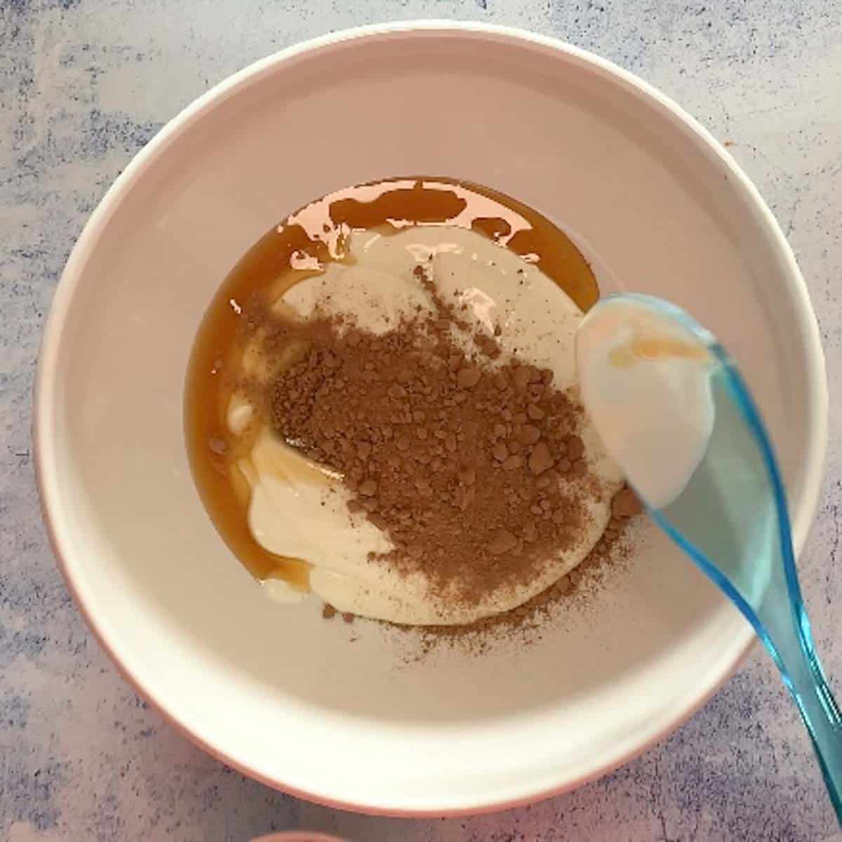 yogurt, chocolate powder, maple syrup in a bowl
