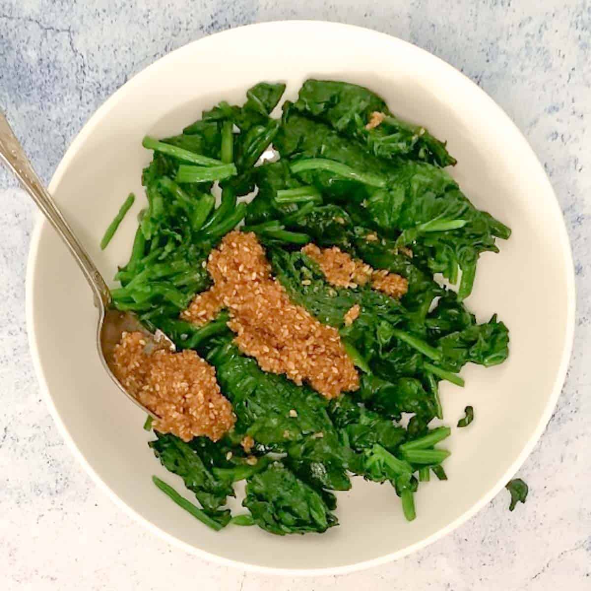 cooked cut spinach in a bowl with Japanese sesame dressing goma