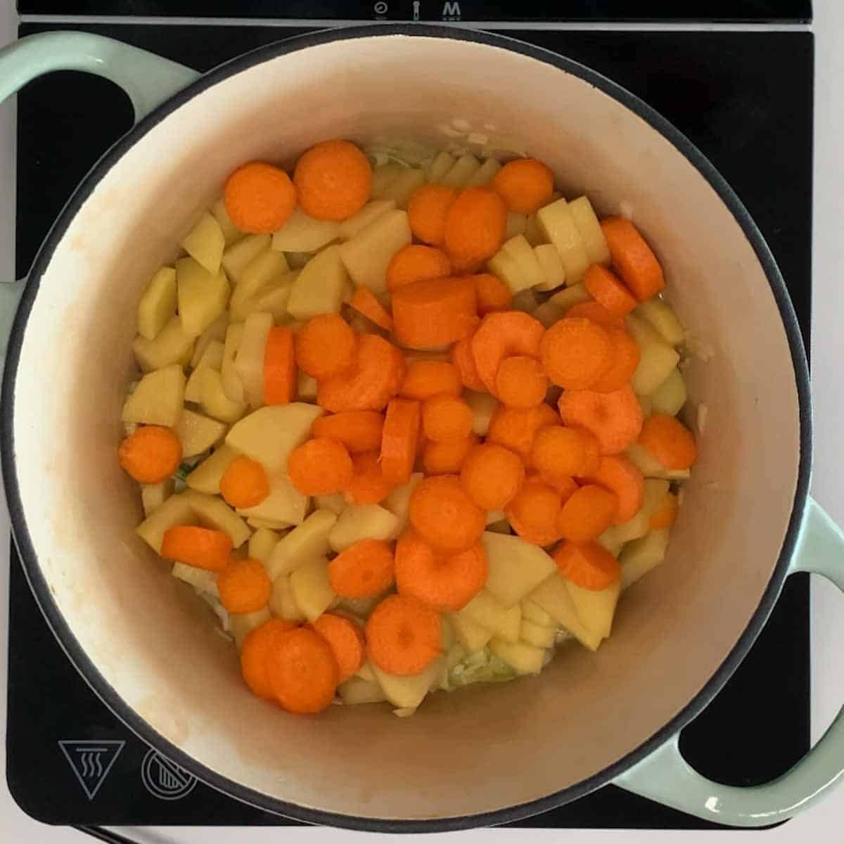 raw potatoes and carrots in a dutch oven