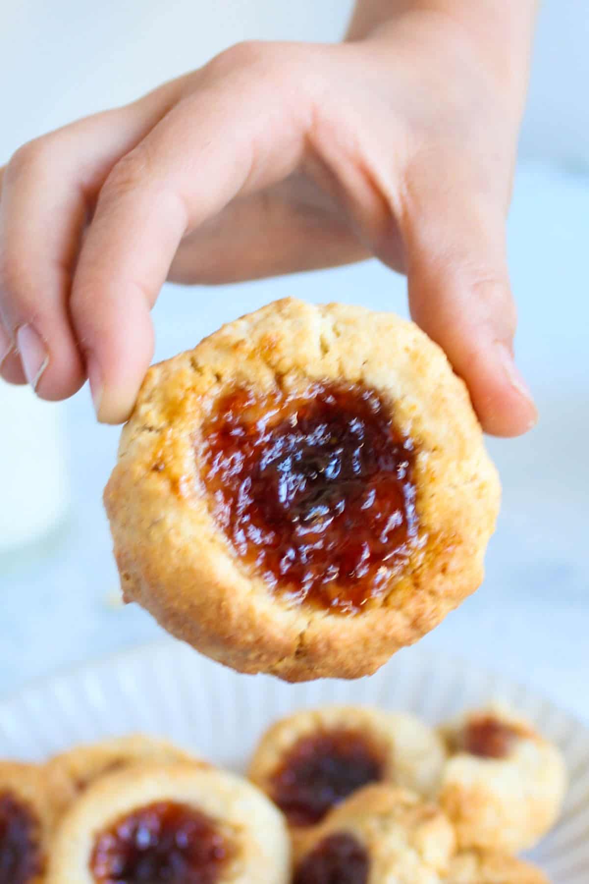 a child hand holding a jam drop cookie