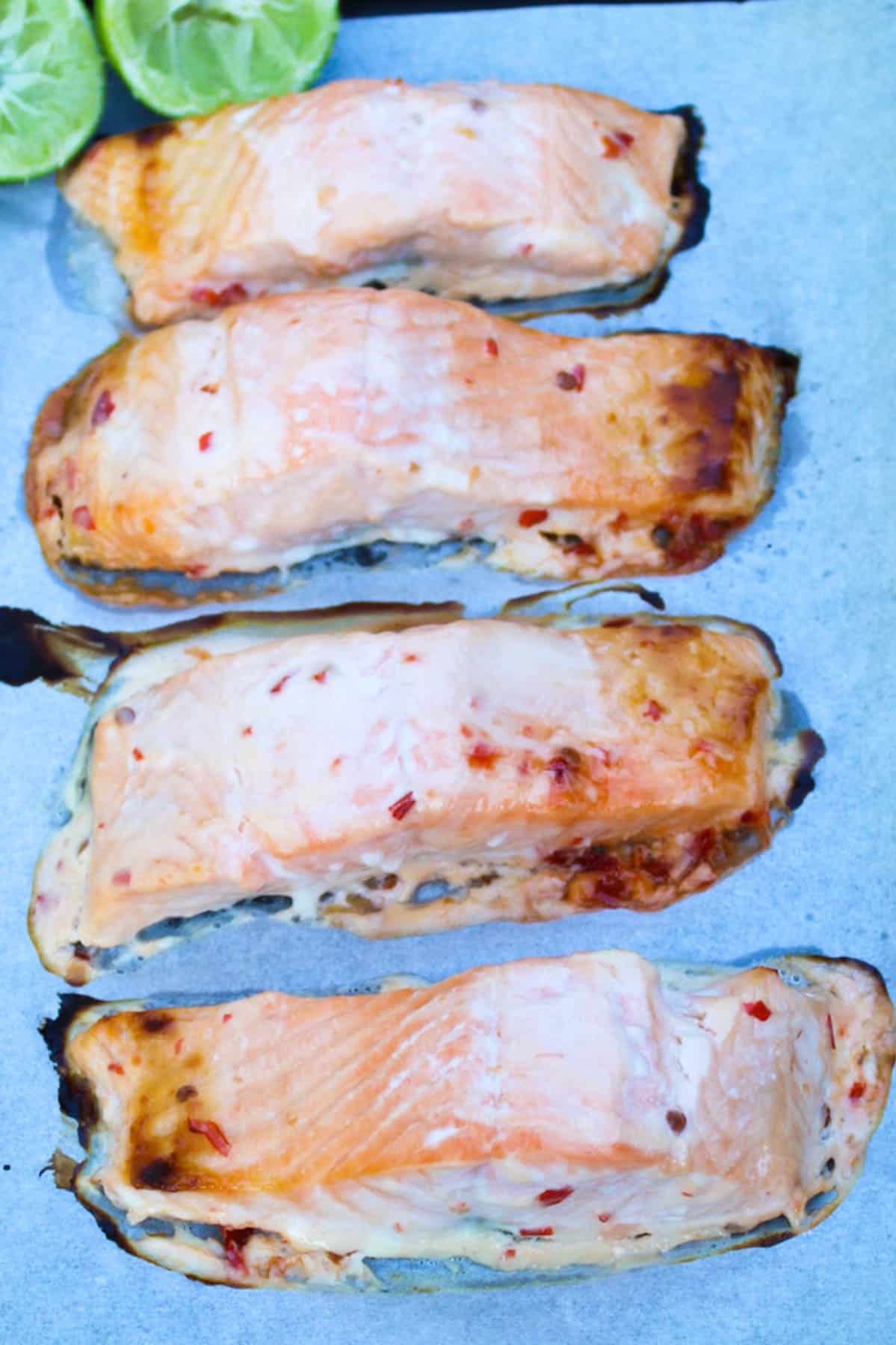 4 baked salmon fillets on a baking tray
