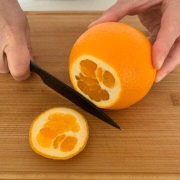 process of cutting the top of an orange