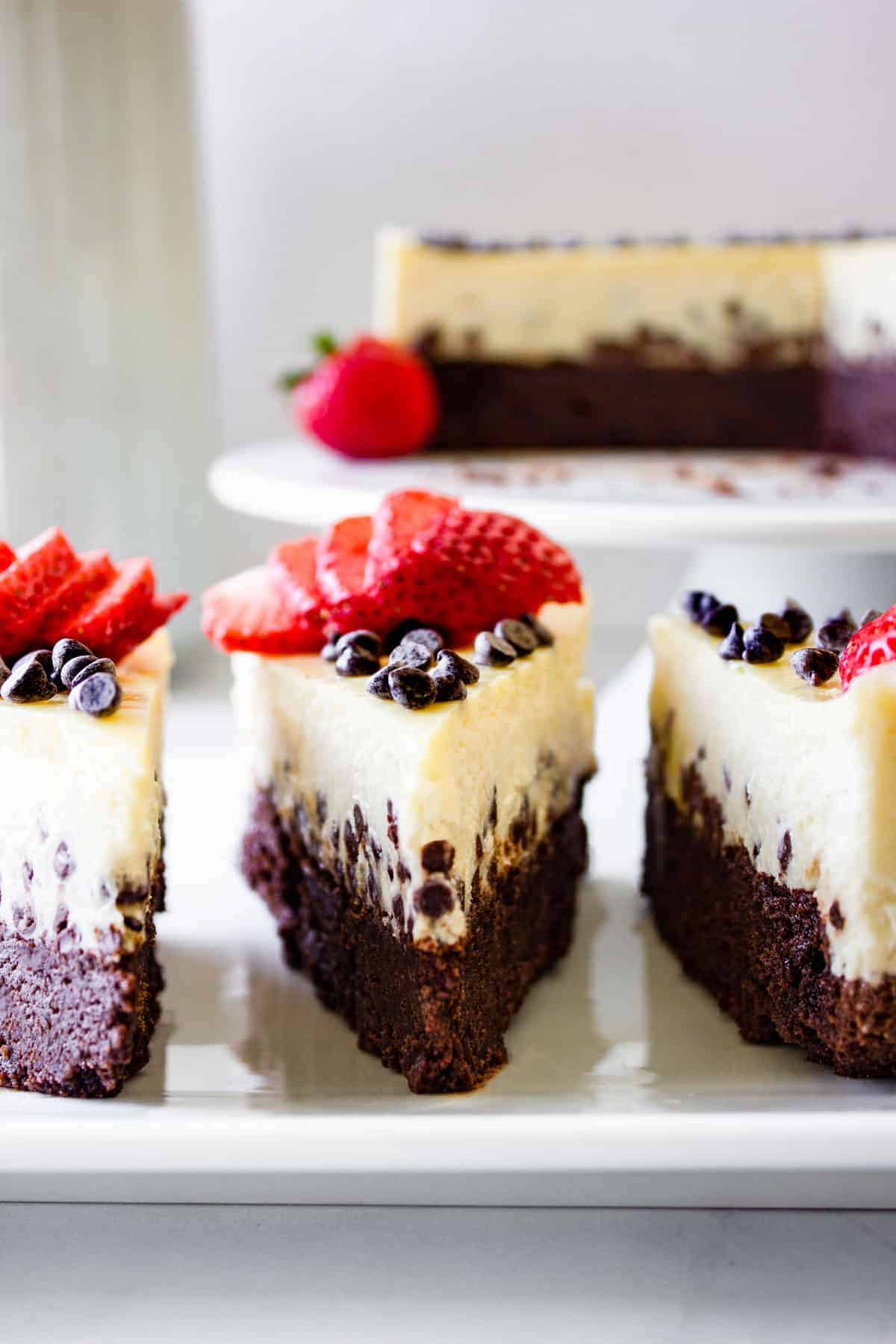 three slices of chocolate cheese cake served with fresh berries