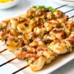 5 chicken kebabs on a square white plate