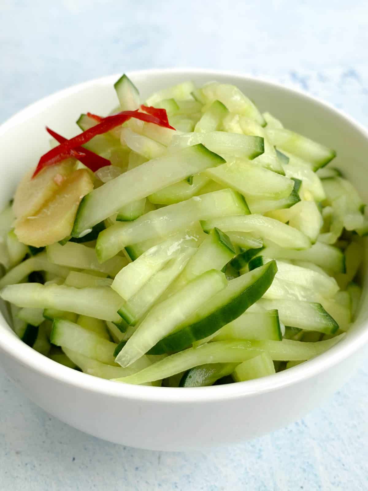 cucumber relish i na small white bowl with ginger slices and chilli 