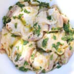 marinated chicken thighs in a white bowl