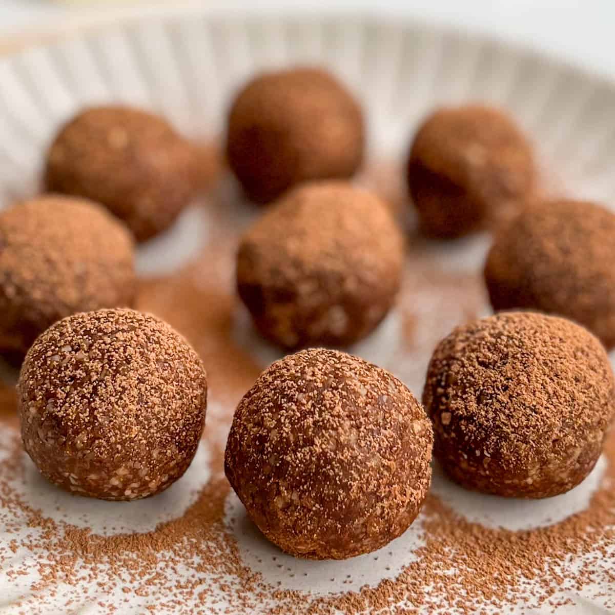Cacao dusted bliss balls on a plate.